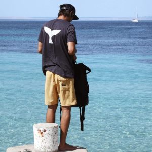 Whale tail tee on the pier by the sea